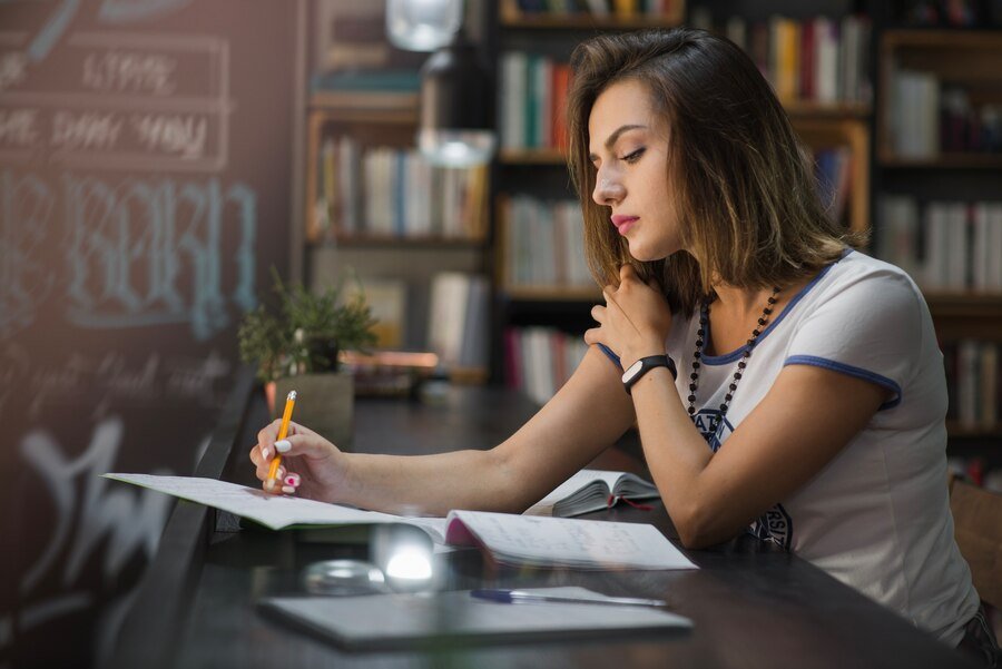 girl sitting table with notebooks writing 23 2147657366